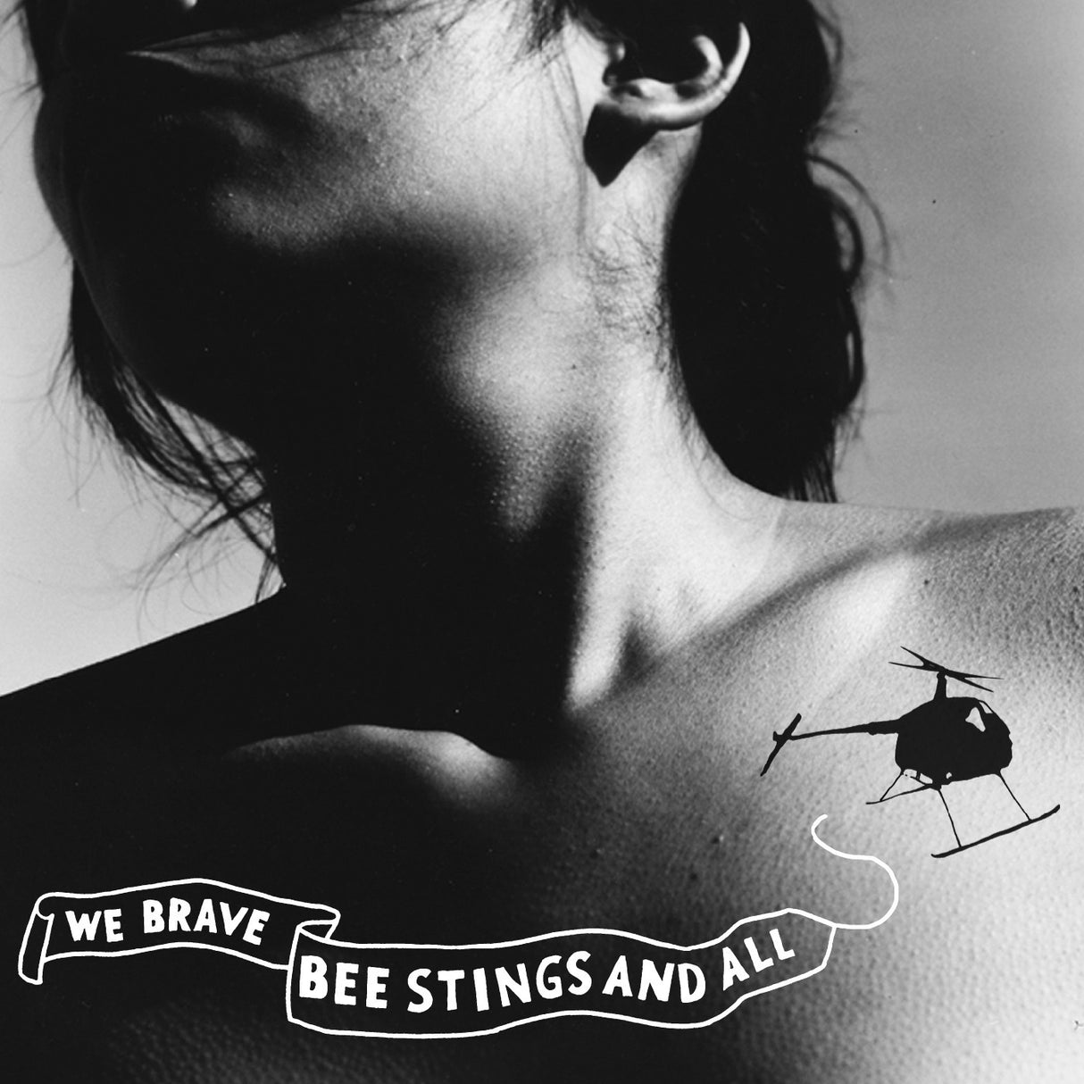 Black and white tattoo of a helicopter and text on a person's shoulder