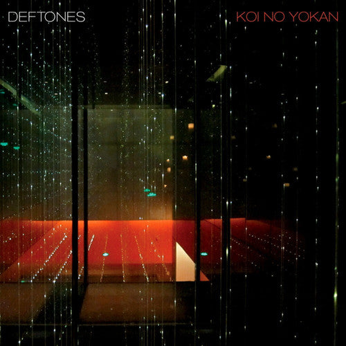 Album cover for Deftones - Koi No Yokan featuring a dark, grainy image of a room with red flooring and a window with a view of stars or glittering lights outside.