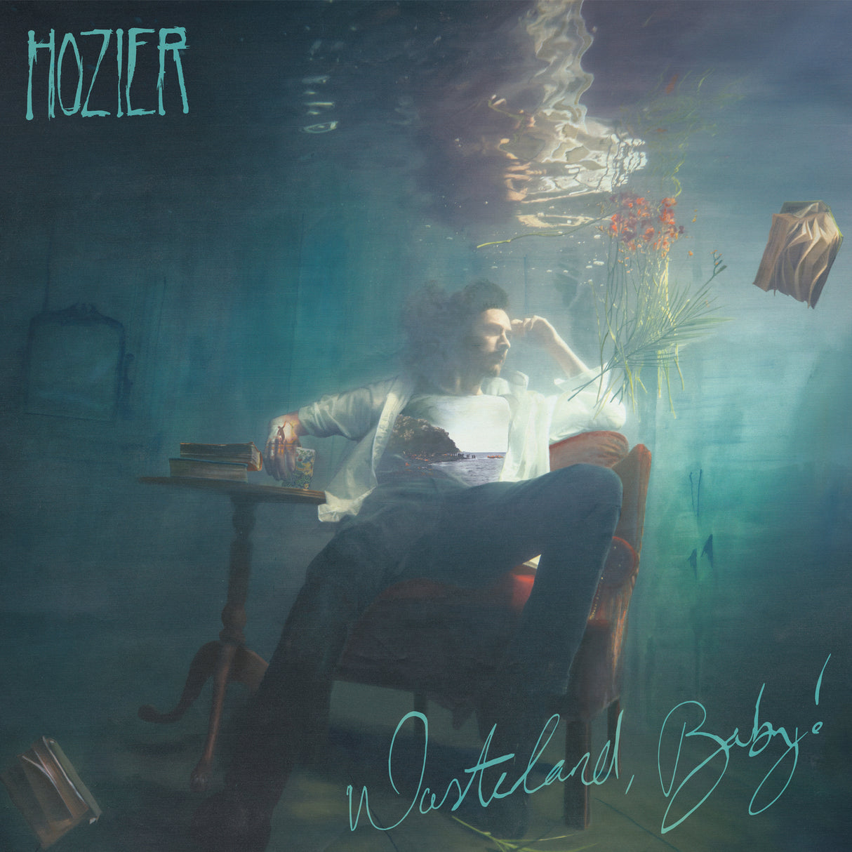 The image features the cover of the album 'Wasteland Baby' by Hozier. The cover artwork depicts a moody, intimate scene with Hozier seated in a chair, holding a book, and surrounded by a decaying set and floral elements that evoke a sense of nostalgia and melancholy.