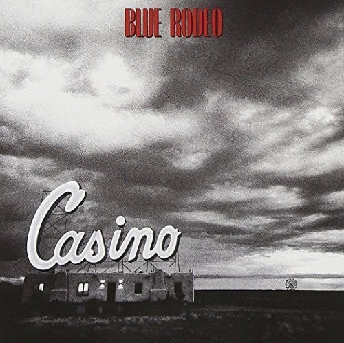 The image features the album cover for "Blue Rodeo - Casino LP," capturing a moody and dramatic scene. The album cover artistically contrasts a vibrant, neon-lit casino sign with a dark, cloud-filled sky, emphasizing a sense of isolation and perhaps a longing for the bright lights of the casino.