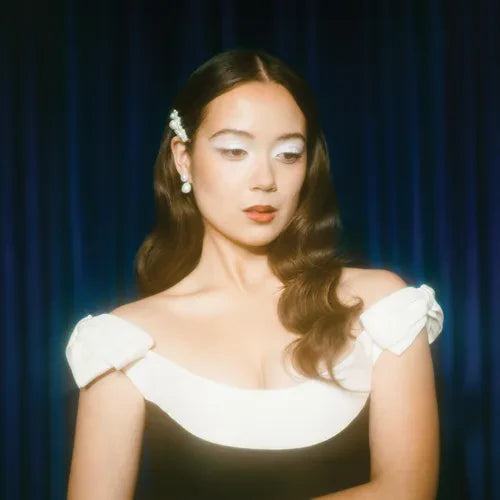 A CD cover featuring a person with long hair wearing a white top, with a blue backdrop. The cover has a glossy, reflective quality typical of CD cases.