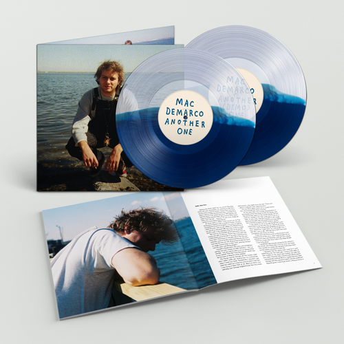Vinyl record set with blue and clear disc, cover, and lyrics sheet on a light gray background