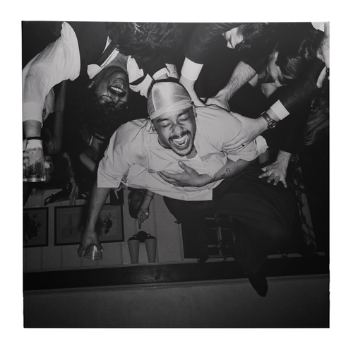 Black and white photo of a man in a crowd at a party