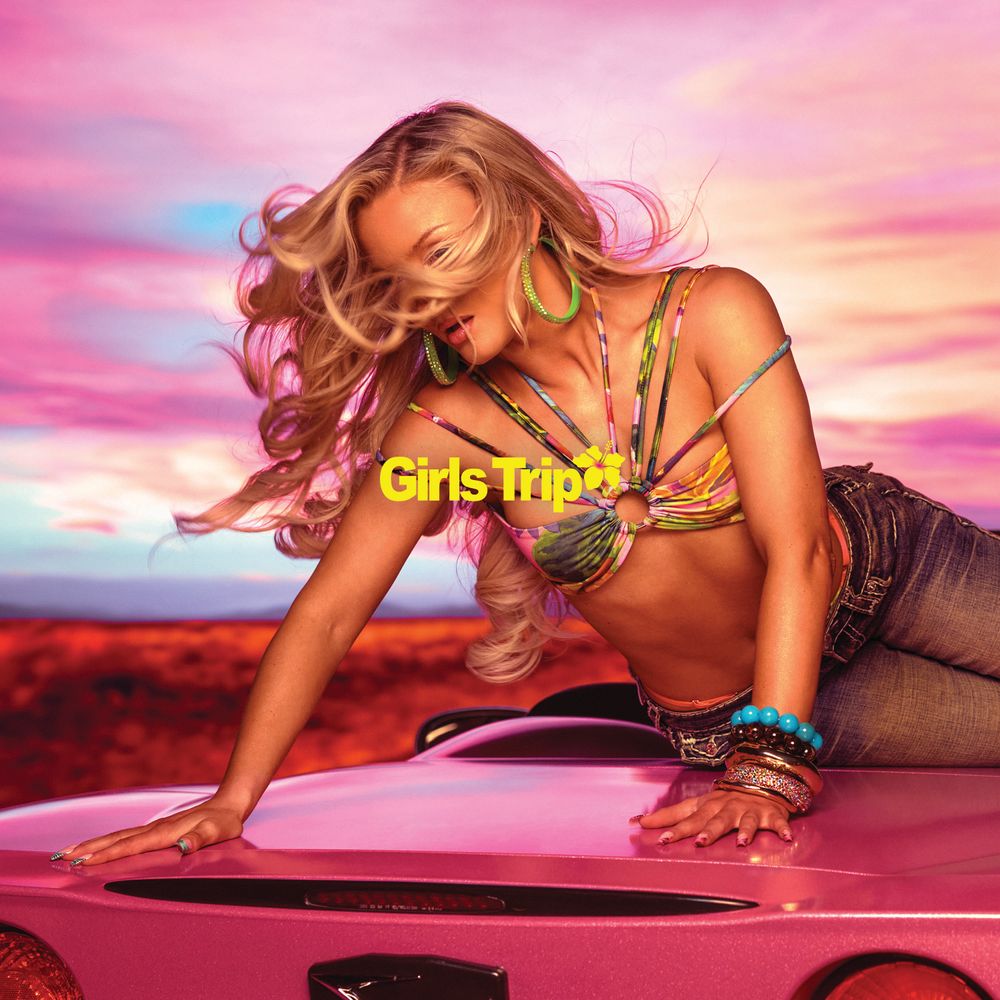 Woman leaning on a pink car with a colorful sky and 'Girls Trip' text.