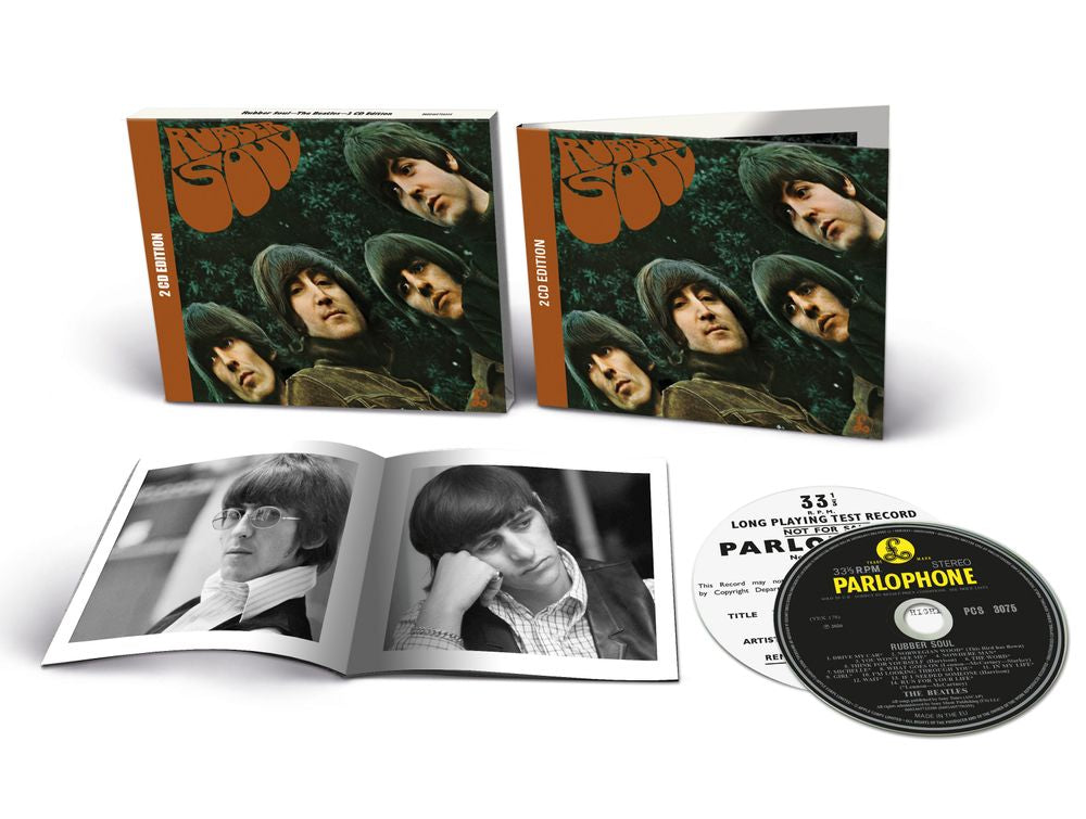 The Beatles 'Paperback Box' 33rpm long playing vinyl record package, showing the illustrated outer sleeve, an open inner booklet with black-and-white photos, the CD single, and the Parlophone label.