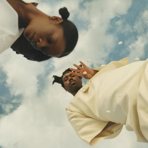 Album cover art featuring two individuals looking upwards against a cloudy sky background.