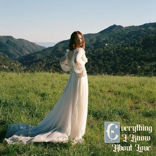 A person standing in a field with a mountainous landscape in the background, wearing a white dress with long sleeves, and the text 'everything I know about love' is visible.