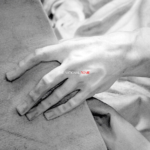 A close-up of a hand holding a piece of fabric, with 'the national rome' text visible in the background.