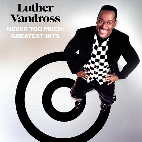 Luther Vandross sitting on a round table with a stylized graphic background, smiling for the camera.