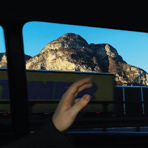Hand holding a smartphone with a mountainous landscape in the background