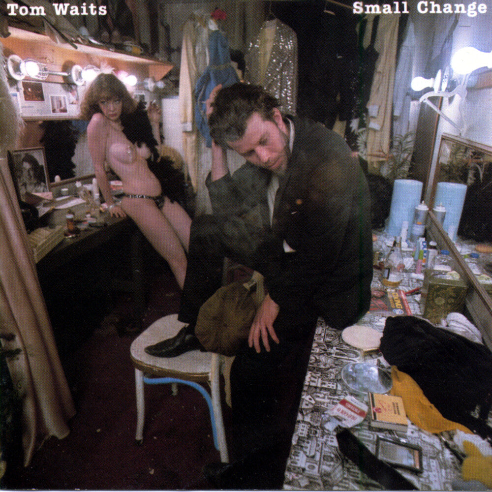 Person adjusting shoes in a cluttered room with 'Tom Waits Small Change' text.