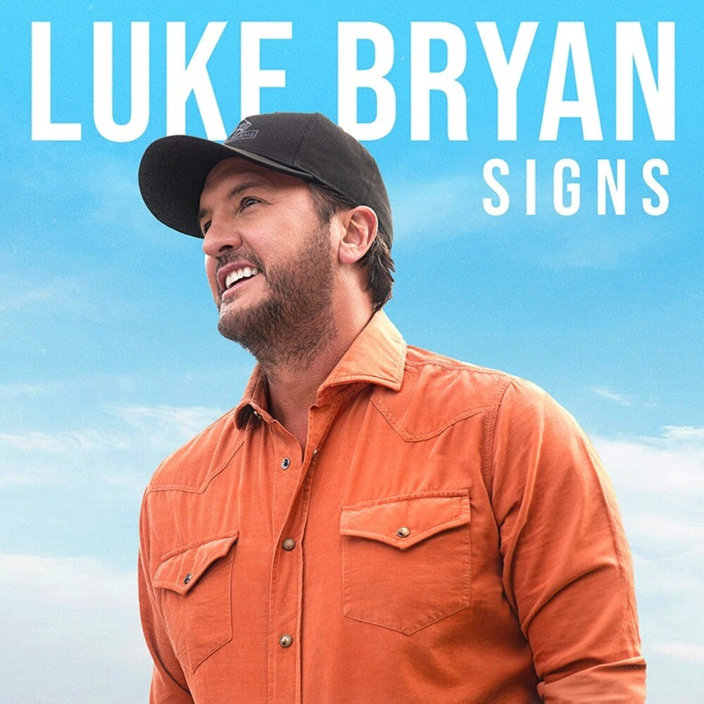 Luke Bryan promotional image with large white text reading 'LUKE BRYAN SIGNS' over a bright blue sky background, featuring a smiling man in an orange button-up shirt and black cap.