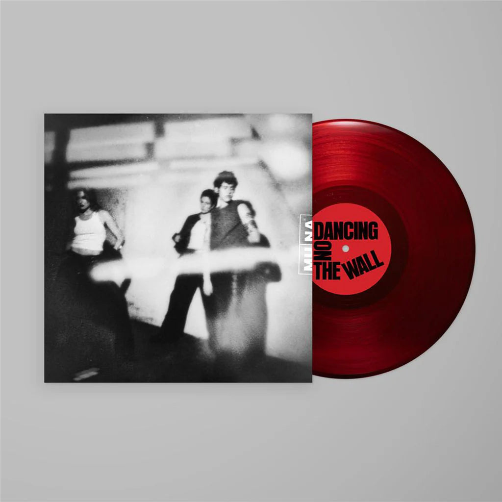 Red vinyl record with a black and white album cover featuring people, on a light gray background.