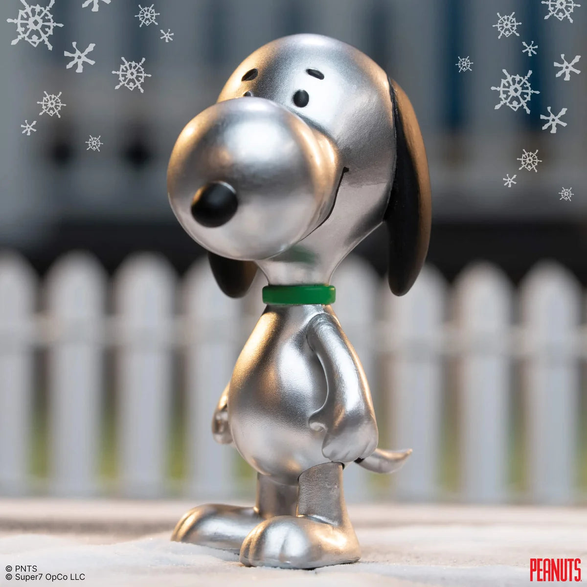 Metallic Snoopy figurine with snowflake decorations in the background