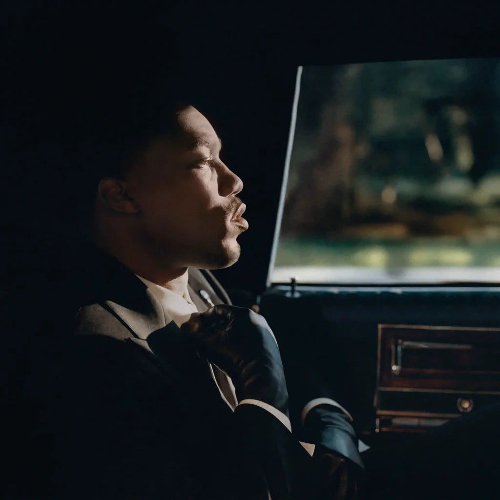 Person sitting inside a vehicle looking out the window at night.