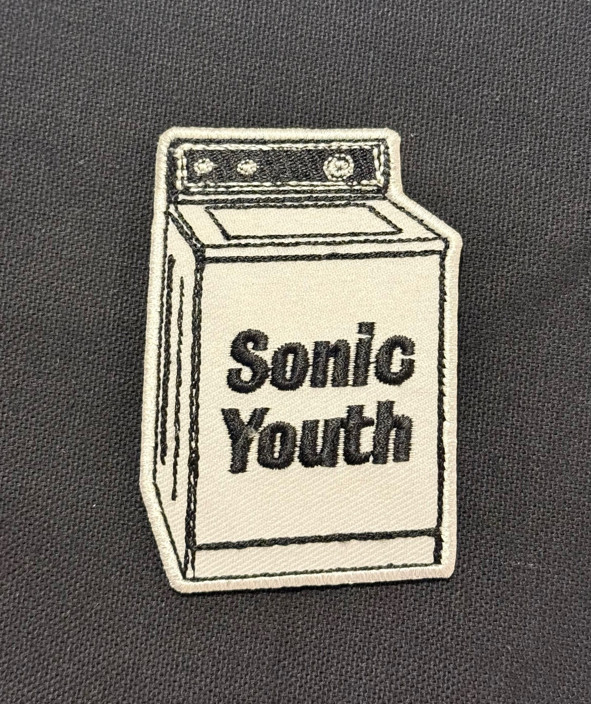 Embroidered patch of a washing machine with 'Sonic Youth' text on a dark background