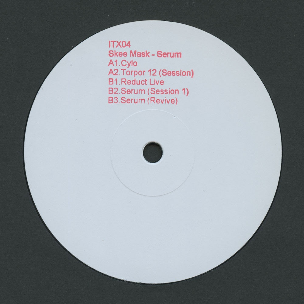 A white vinyl record label with red printed track listing text on a dark gray background.
