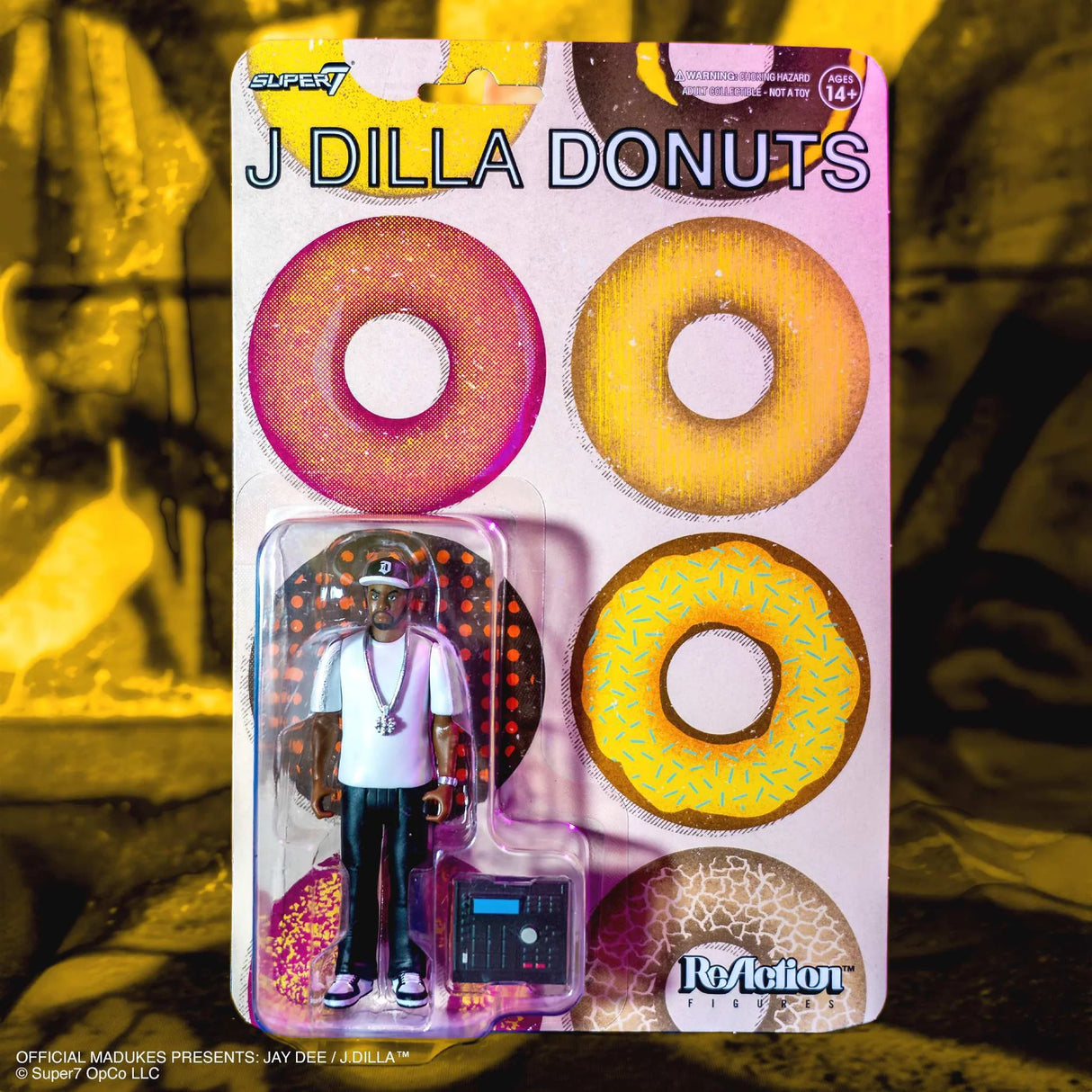 Packaged toy figure of J Dilla with donut-themed packaging