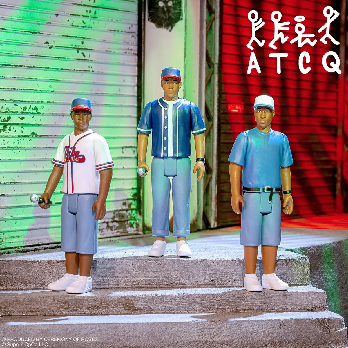 Three collectible action figures of baseball players styled after real-life victims of the Atlanta traffic crash, posed on concrete steps in front of a closed shutter. The figures are dressed in baseball and athletic uniforms.