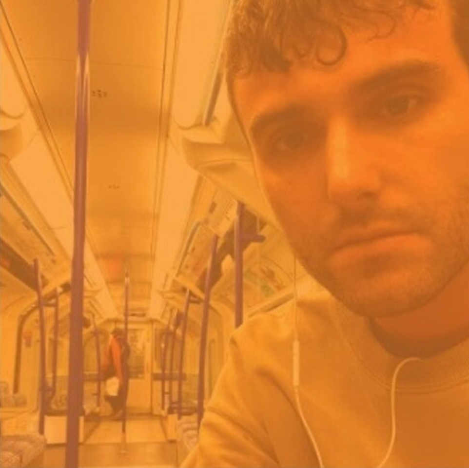 An album cover featuring a person looking out of a vehicle window, with a blurred background that suggests motion, possibly on a train or bus. The image has a warm, orange hue.