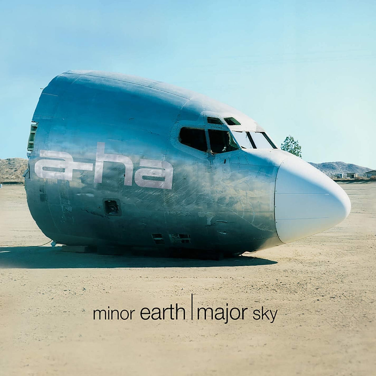 Large airplane fuselage on a desert ground with 'ethereal' branding and text 'minor earth | major sky'.