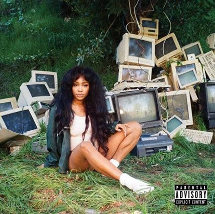 An album cover featuring the artist SZA sitting on grass with an accumulation of old computers behind her, including the text 'Parental Advisory' on the bottom right.