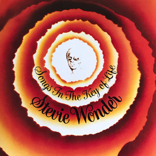 Album cover for Stevie Wonder's 'Songs In The Key Of Life' featuring a spiral design with red, orange, and yellow hues, and Stevie Wonder's face in the center.