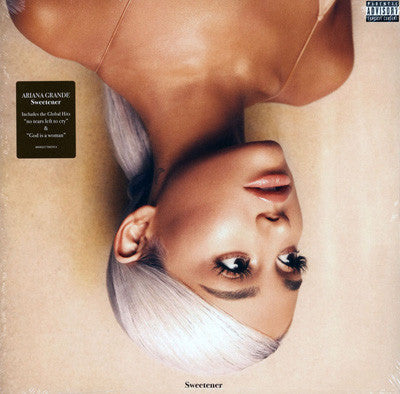 This image features the album cover for "Sweetener" by Ariana Grande. The artwork is striking, showcasing a close-up of Ariana's face in an upside-down orientation against a warm, earth-toned background.