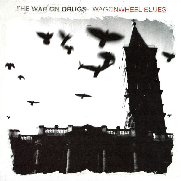 Album cover for The War On Drugs - Wagonwheel Blues featuring a black and white photograph of a castle with silhouetted birds flying around it.
