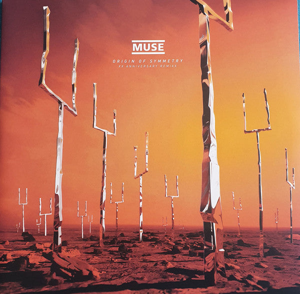 A album cover with the band Muse and the title 'Origin of Symmetry'. The cover features a red and orange desert landscape with tall, slender tree-like structures.