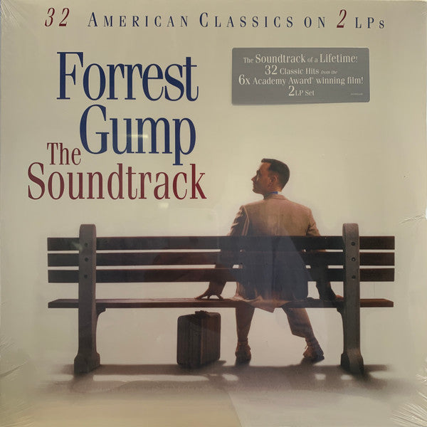 Album cover for 'Forrest Gump' soundtrack featuring the title character sitting on a bench with a suitcase and a guitar case beside him.