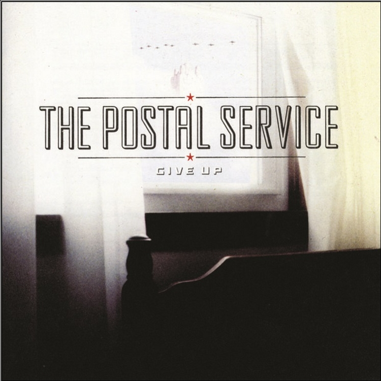 Album cover for The Postal Service's 'Give Up' featuring a dark and moody image with a piano and curtains.