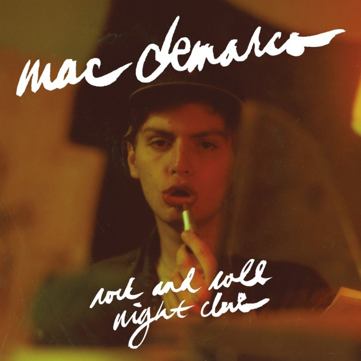 Album cover for Mac DeMarco's 'Rock And Roll Nightclub LP' featuring a photo of Mac DeMarco with a stylus, in a dimly lit environment, with the album title written in a casual script.