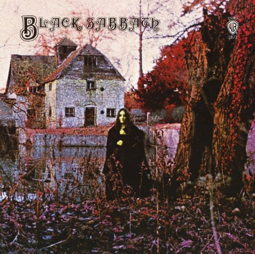 The album cover of Black Sabbath featuring a man in a black robe standing in front of a house with a red tree in the foreground.