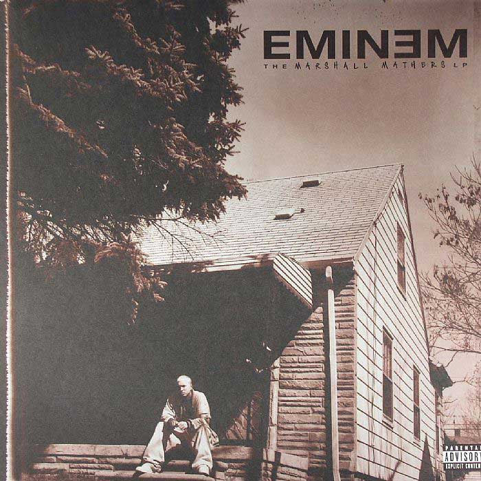 Album cover of Eminem's 'The Marshall Mathers 180g 2LP' featuring a black and white image of a man sitting on a wall beside a house.
