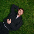 Man in a suit lying on grass