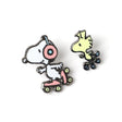 Two cartoon character pins on a white background