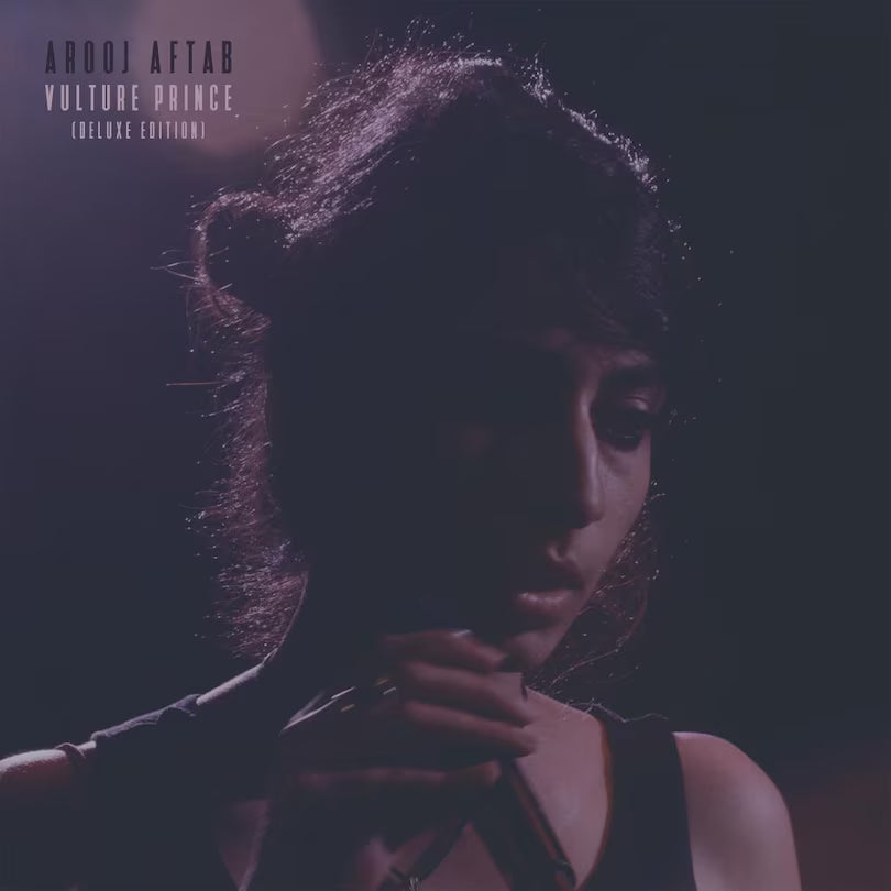 Album cover with a person holding a microphone against a dark background, featuring the text 'Arooj Aftab Vulture Prince Deluxe Edition'.