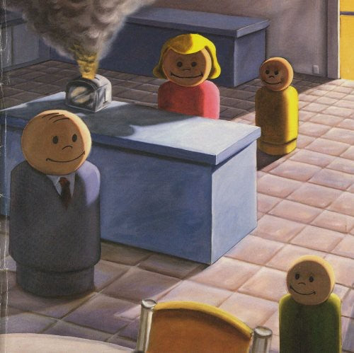 Wooden figures with smiling faces in a room with a desk and a cat.