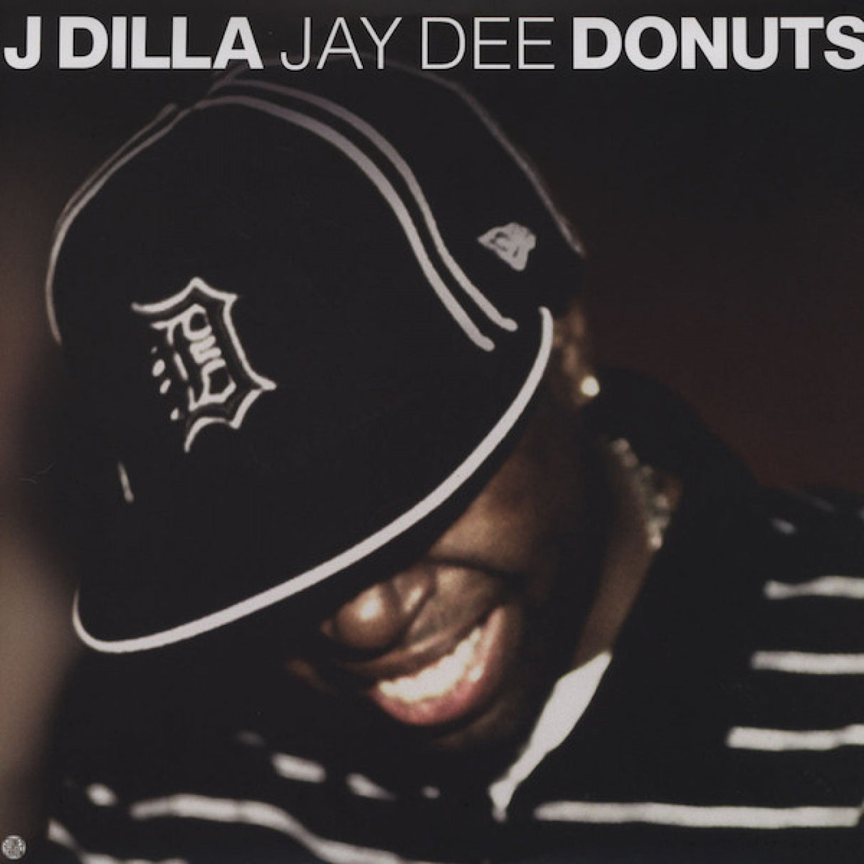 Album cover with a person wearing a cap and text 'J Dilla Jay Dee Donuts' on a dark background