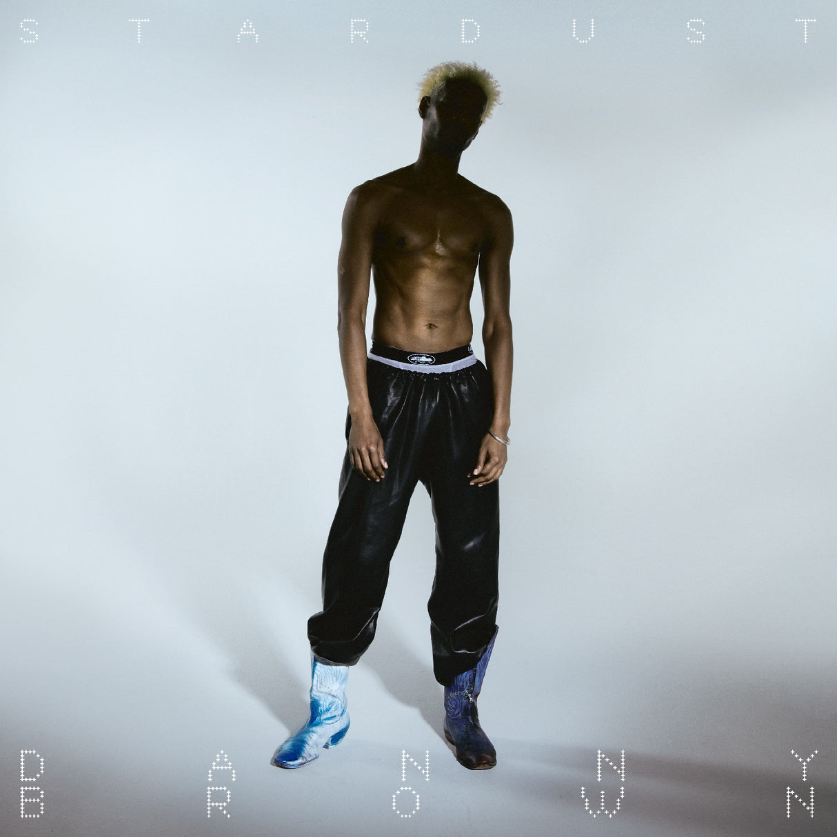 Album cover with a person wearing black pants and blue shoes on a light gray background