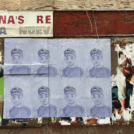 Sheet of paper with multiple images of a person wearing a cap, attached to a wall with peeling paint.