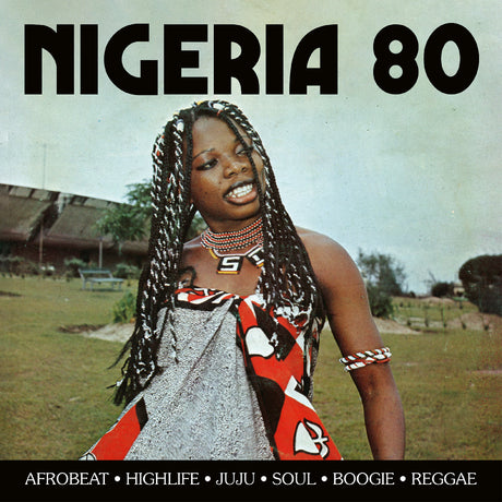 Album cover for 'Nigeria 80' featuring a woman with long braids wearing a red, black, and white patterned garment, with bold black text at the top and bottom on a grassy outdoor background.