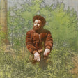 A vintage-style illustrated portrait of a bearded man in a brown jacket kneeling among green plants and trees, rendered in muted earthy tones.