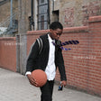 Person holding a basketball against a brick wall with 'Essex Honey' branding.