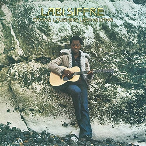 Album cover featuring a person with a guitar sitting on rocks by the water, with 'Labi Siffre' and album title text.