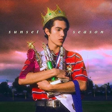 Person holding trophies and a crown with 'sunset season' text against a colorful sky.