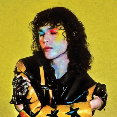 Person with colorful makeup and a black leather jacket on a yellow background