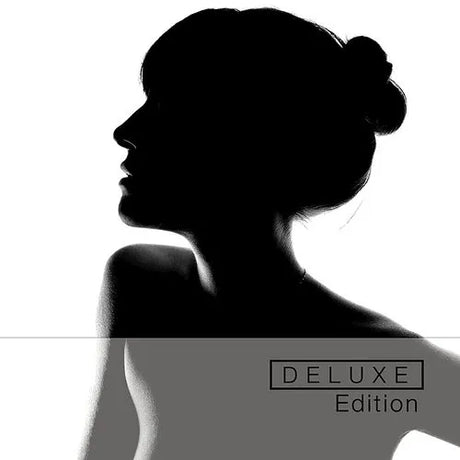 A black and white image of a person with a visible face and neck, labeled 'DELUXE EDITION'.