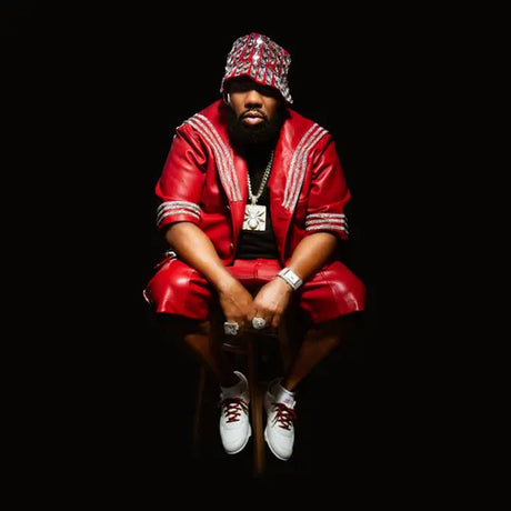 Person wearing a red outfit with white accents, sitting on a black background